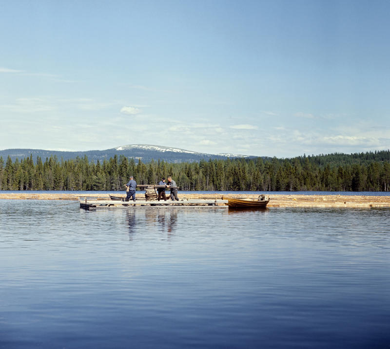Fire menn går rundt et gangspill på en spillflåte ute på en av Ulvesjøene i Trysil.