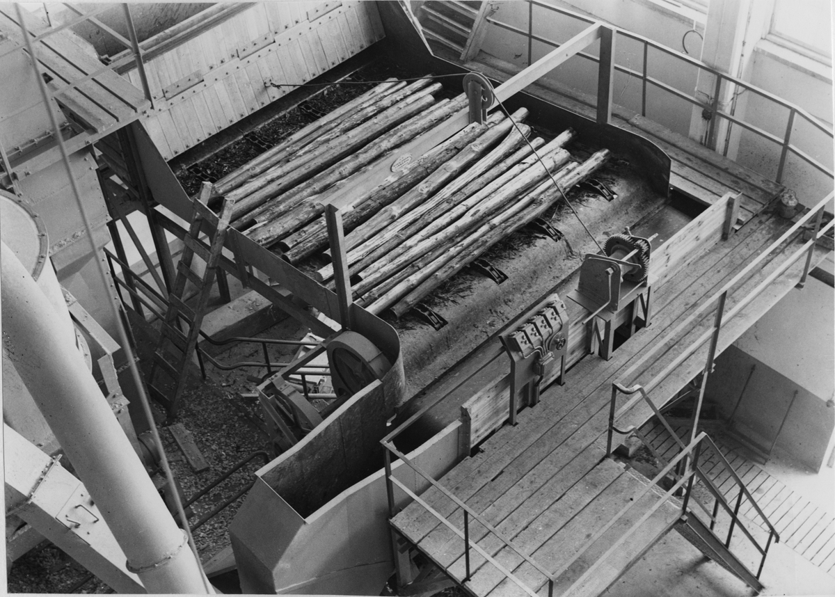 Karlholms Aktiebolag. Tillverkning av träfiberplattor. Klamparna går ner i tuggningsmaskinen.