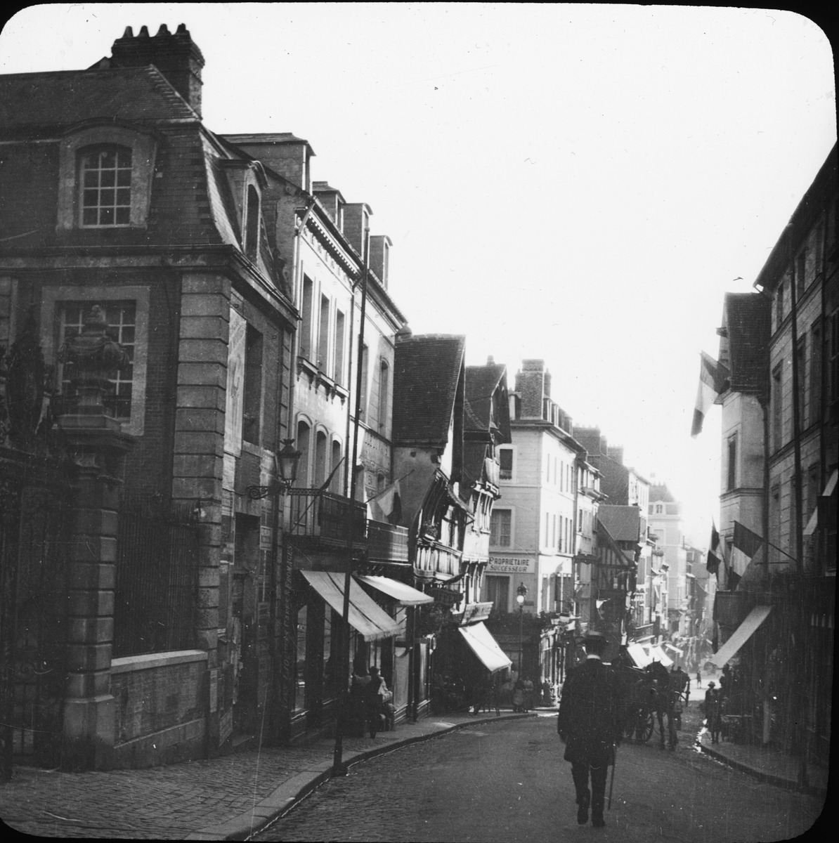 Skioptikonbild med motiv från Grand Rue i Lisieux.
Bilden har förvarats i kartong märkt: Resan 1908. Rouen 3. Lisiaux 5. VIII. Text på bild: "Grande Rue".