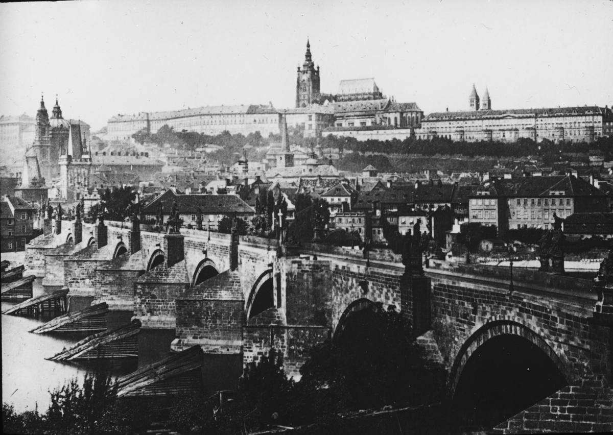 Skioptikonbild med motiv av vy över Prag och Karlsbron.
Bilden har förvarats i kartong märkt: Höstresan 1909. Prag 8. No:3.