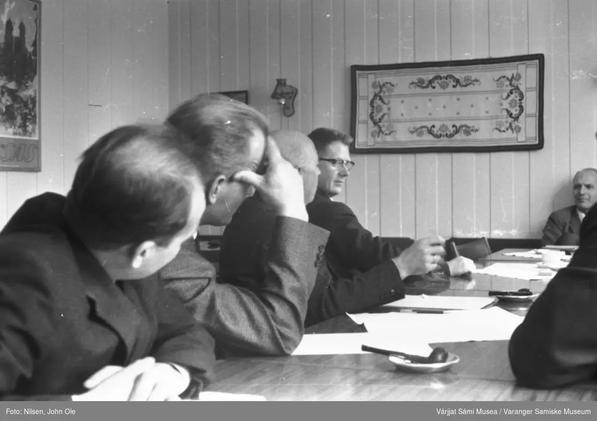 Seks personer samlet til et møte. Samme sted som på VSM.F.000809. Mannen med briller ved enden av bordet er Karstein Evjen fra Vestre Jakobselv. Ukjent sted, 1966.