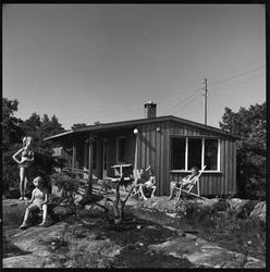 Hydrostranda. Familie ved hytte på Varden.