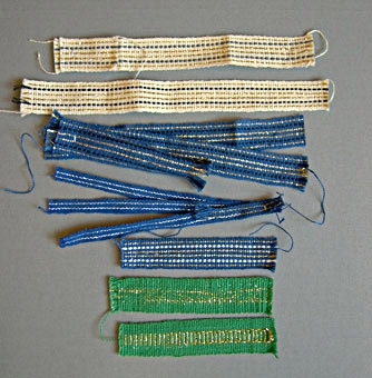 Tjugotre stycken prover på vävda band i linne. Banden, i olika färger, mönster och bredder är vävda i rips. De flesta är band framtagna till kyrkliga textilier. Varp och inslag i oblekt, halvblekt och kulört lingarn och guld- eller silvertråd. 
WLHF-0366:1-14 med guld och/eller silvertrådar.
WLHF-0366:15-20 olika mönster och färger.366:17 är märkt med en etikett med texten: "Band Värmland vävt 82 1/2 öre + 10%", med provtrådar i oblekt, blått och rödbrunt under etiketten.WLHF-0366:21-23 halvblekta/oblekta, omönstrade, olika grovlek och bredd. Första bilden visar WLHF-0366:1-7. Andra bilden visar WLHF-0366:8-14. Tredje bilden visar WLHF-0366:15-23.