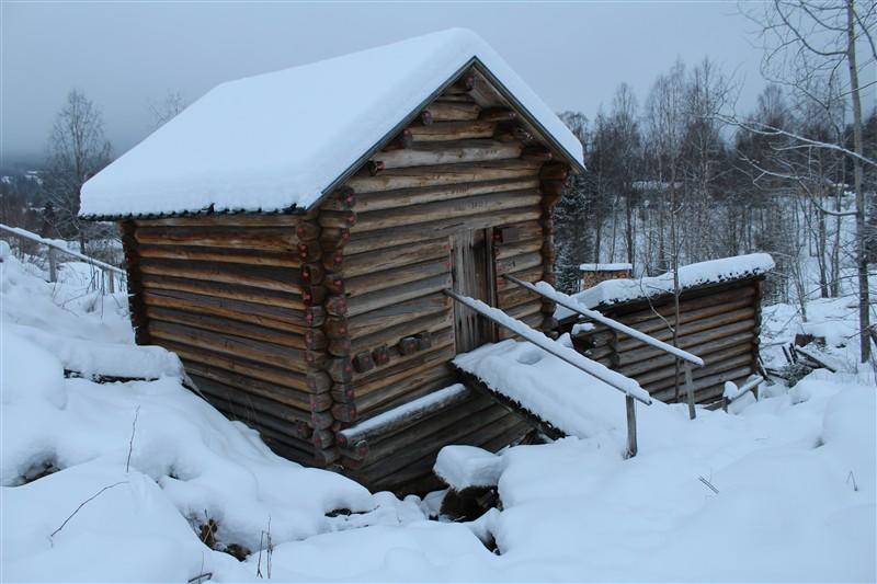 Oversiktsbilde av Kvenna. Bilde er tatt på vinteren med snø rundt og på taket.
