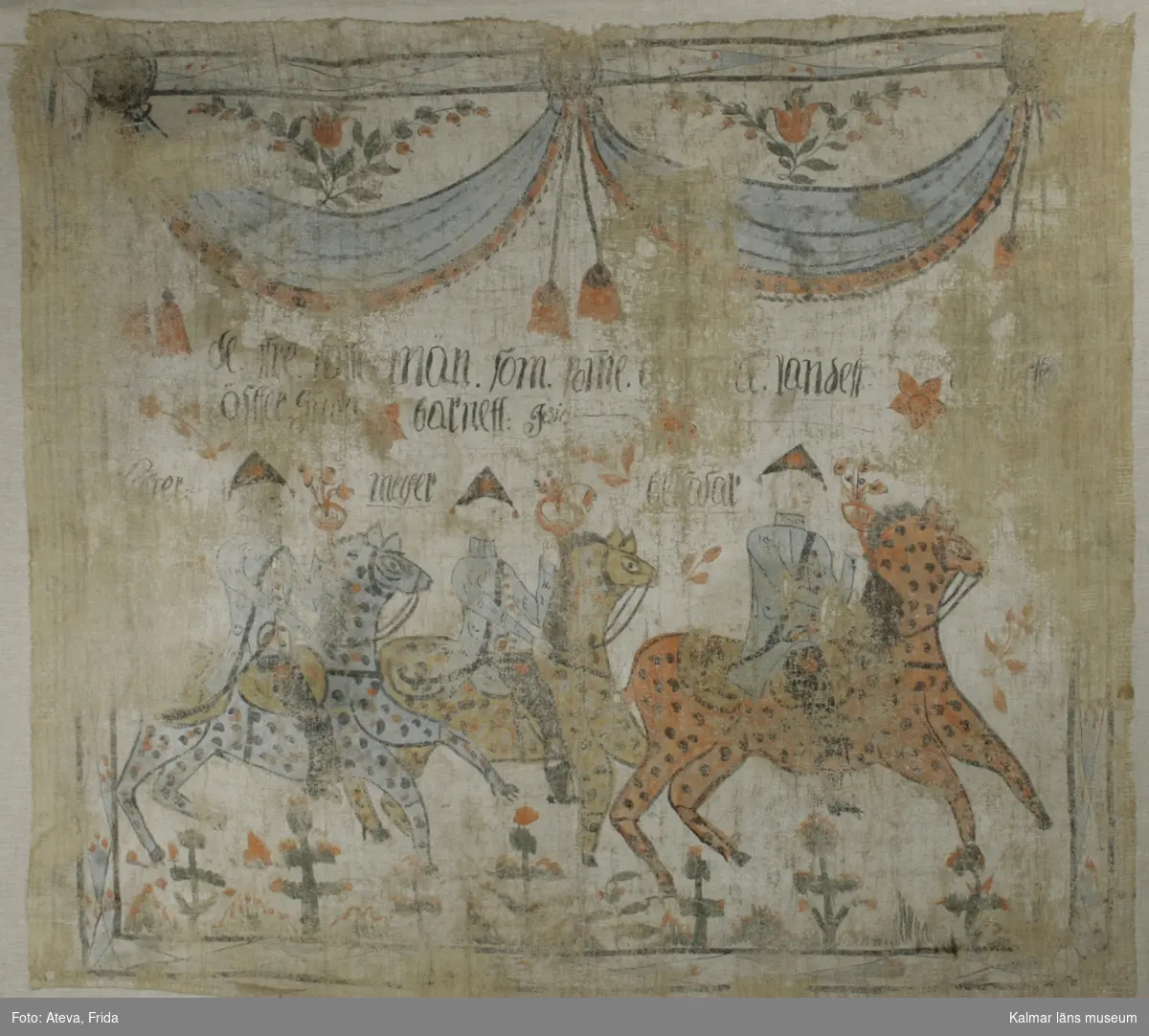 KLM 9132. Bonad av väv. Fäst på stödväv. Målat motiv med de tre vise männen till häst. Vänstra hästen i blått med svarta och röda prickar. Hästen i mitten är gul med svarta, blåa och röda prickar. Hästen till höger i rött med svarta prickar. Vid de tre vise männen står deras namn skrivet i svart, troligen Kaspar, Melker och Baltasar. Över deras huvuden text: de tre vise män som (?)orne .. landet äffter Gud(?) barnett. Överst draperi i blått och rött med röda tofsar. Även blomsterslingor. Runt om bård med geometriskt mönster i blått och rött.