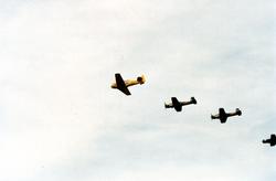 Fire fly i formasjon under et flystevne., T-6 Harvard og Yak