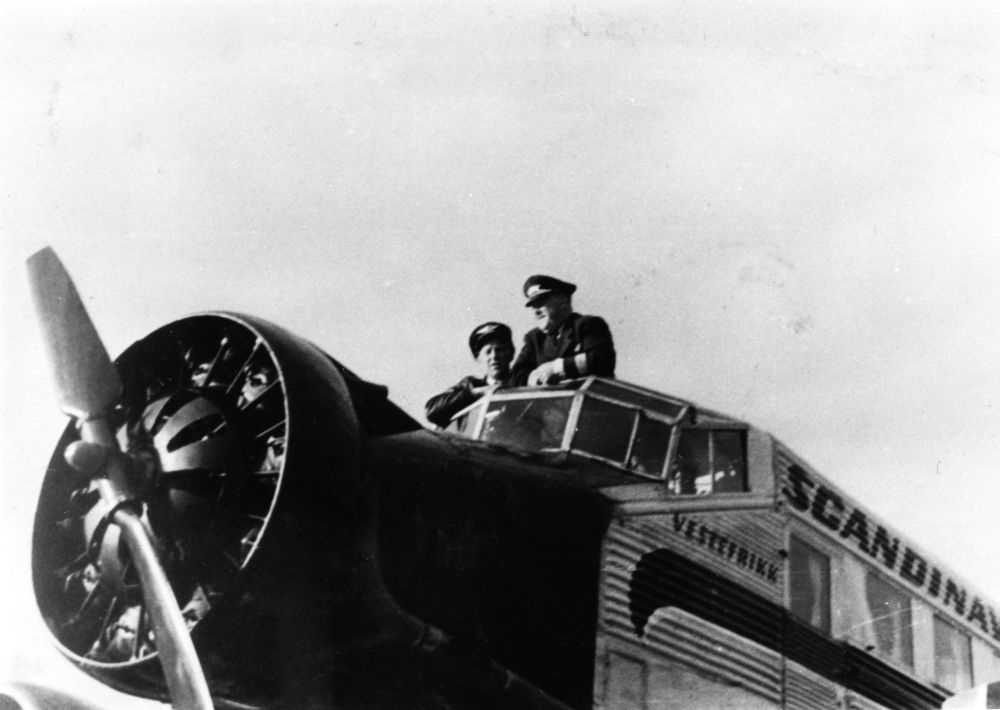 Landskap. Tromsø, Skattøra. To personer på toppen av et fly, Junkers 52, "Veslefrikk"  fra DNL