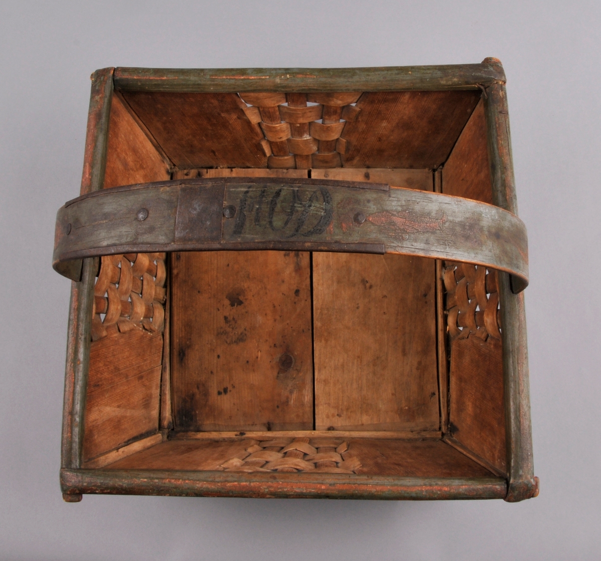 Sendingskorg, grøn botnfarge med rosemåling i fargane: kvit, raud, brun og svart. Initsialar er måla oppe på handtaket. Fletting med spon midt på alle sider. Hanka er forsterka med eit metallband som er festa med fire naglar.