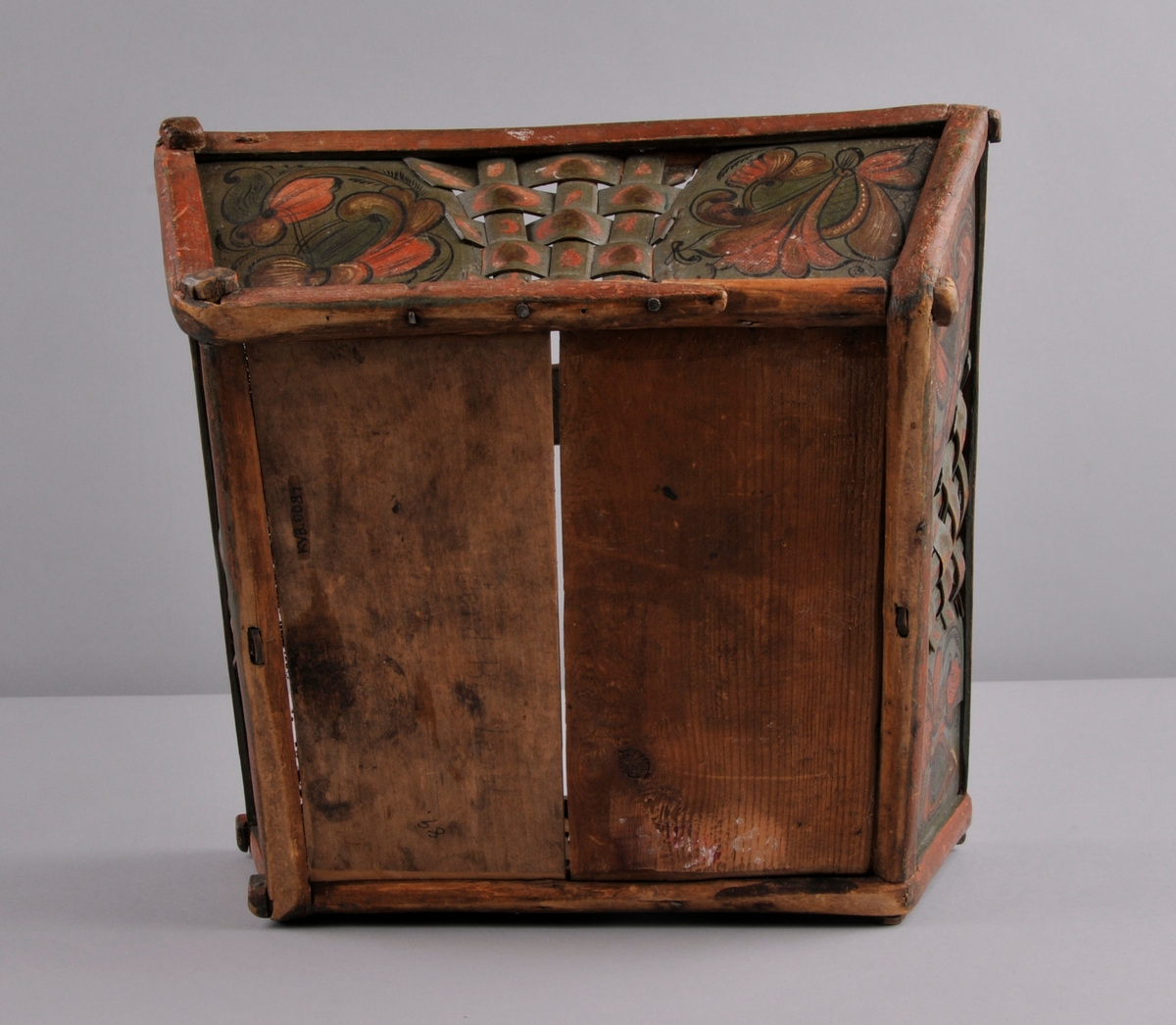 Sendingskorg, grøn botnfarge med rosemåling i fargane: kvit, raud, brun og svart. Initsialar er måla oppe på handtaket. Fletting med spon midt på alle sider. Hanka er forsterka med eit metallband som er festa med fire naglar.