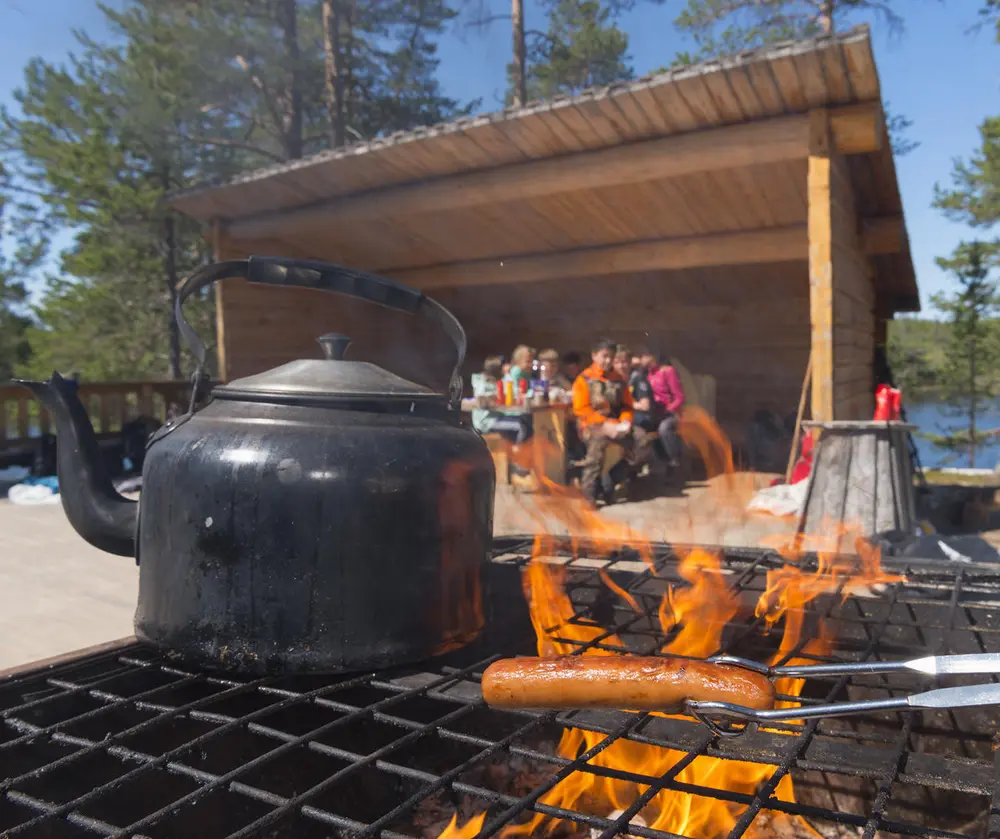 Pølsegrilling og kaffekoking på over et bål på festplassen.