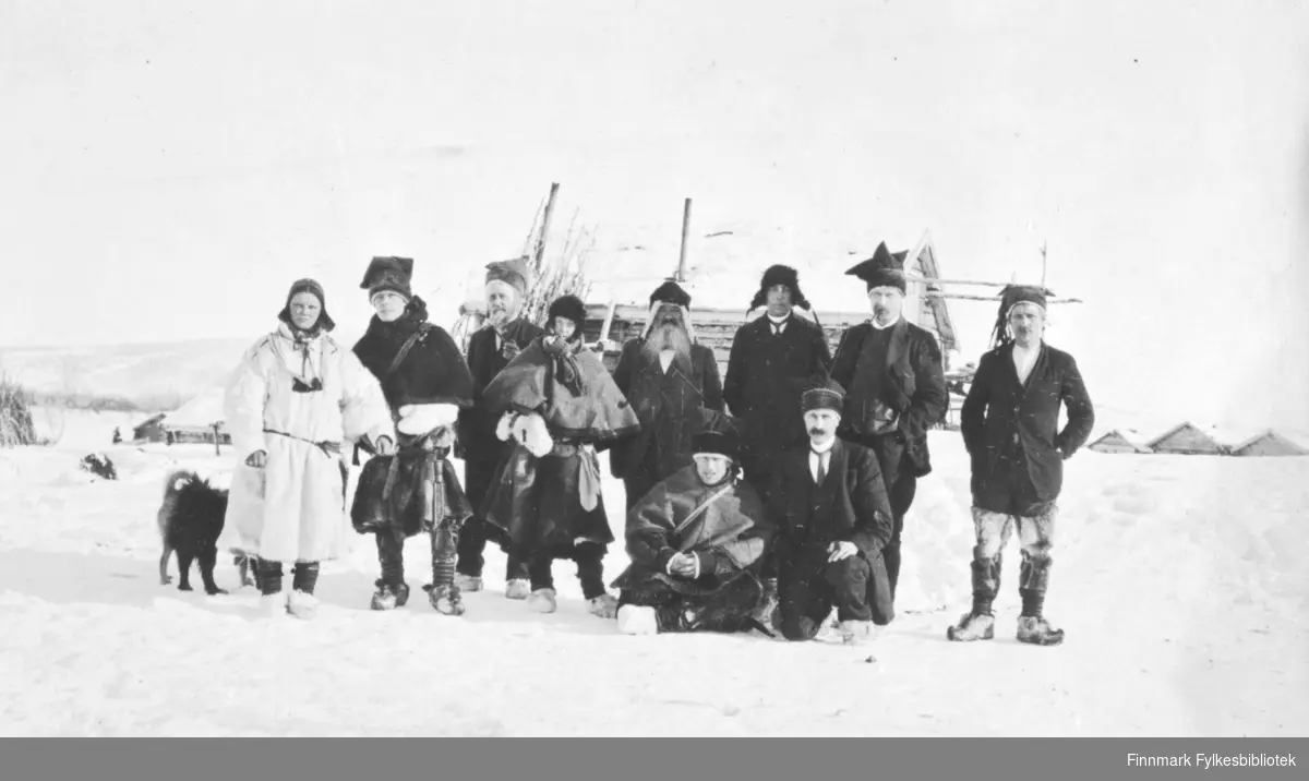 "Retten fra Østen og Vesten paa Sjursjavre, mars 1917". Gruppebilde av nordmenn og samer i pesk og samiske luer.