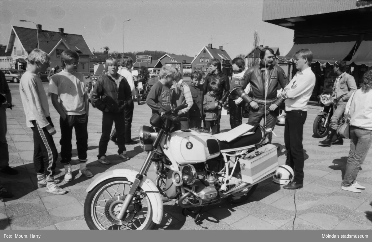 Kållereds Motorklubb visar upp motorcyklar i Kållereds centrum, år 1984. MC-polis Lennart Johansson i samspråk med Mc-klubbens ordförande Dennis Byström

För mer information om bilden se under tilläggsinformation.