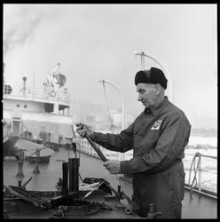 Kontrollør Oksum i arbeid på båt. Oljekai