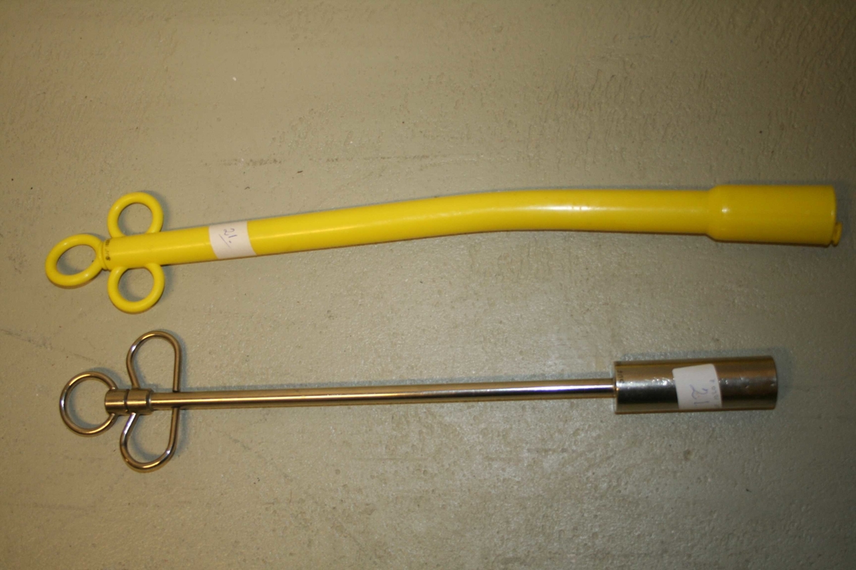 Instrument for å legge inn magnet i vomma på storfe, 2 stk. Llang stav med innvendig rør, og ein sylinder i enden av røret.