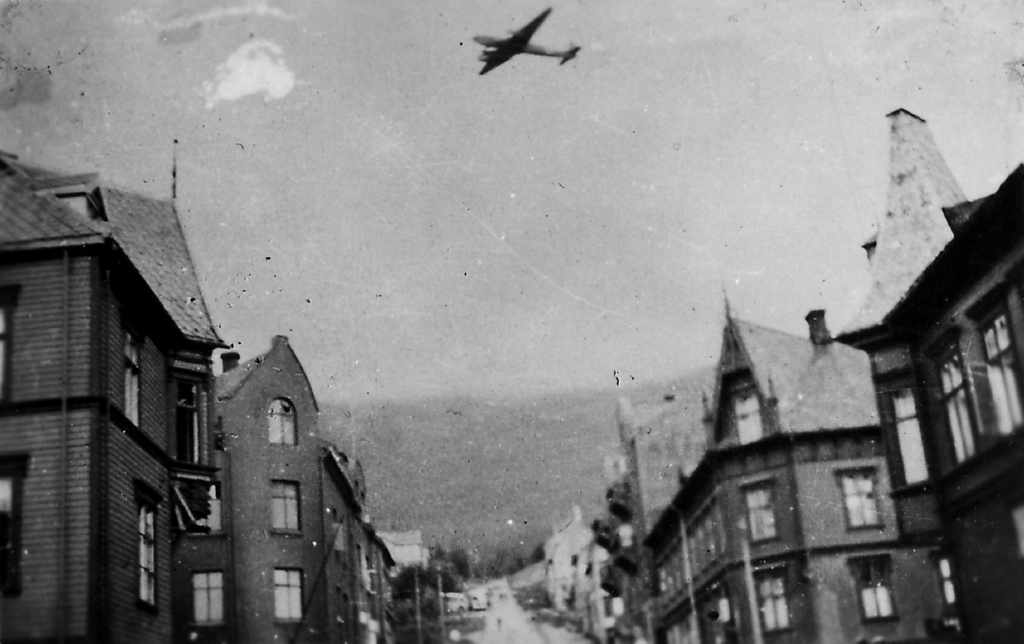 Fly over Narvik: "Heivings fotoalbum: "Innledning til flyangrep i  Narvik den"Fokker Wulf Condor FW-200 over Brannbakken.
Foran til v: Ofotens tidende og Iversengården.
Foran til h.: Nordvikgården og Capitol.