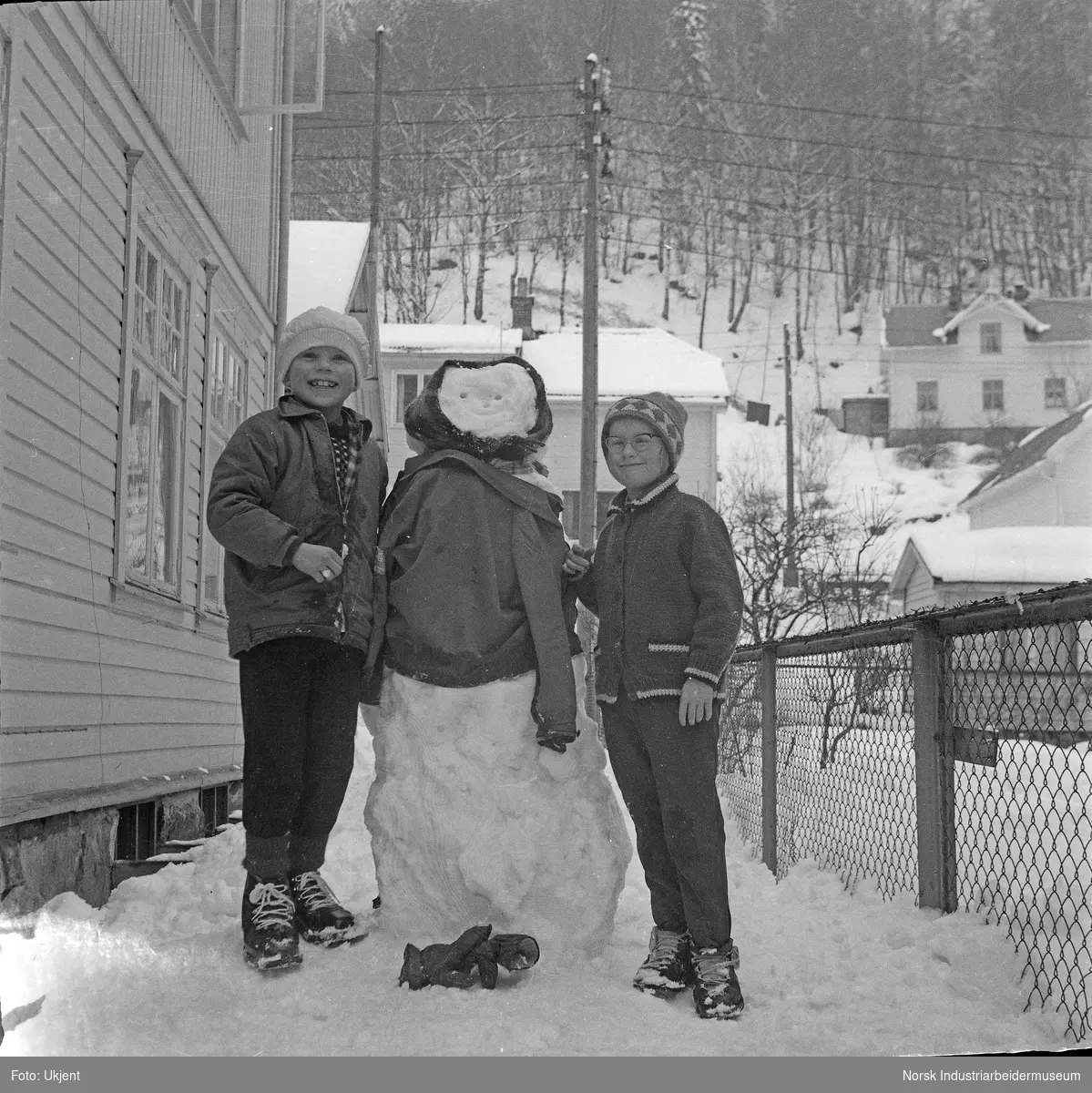 To barn med snømann i Storgata.