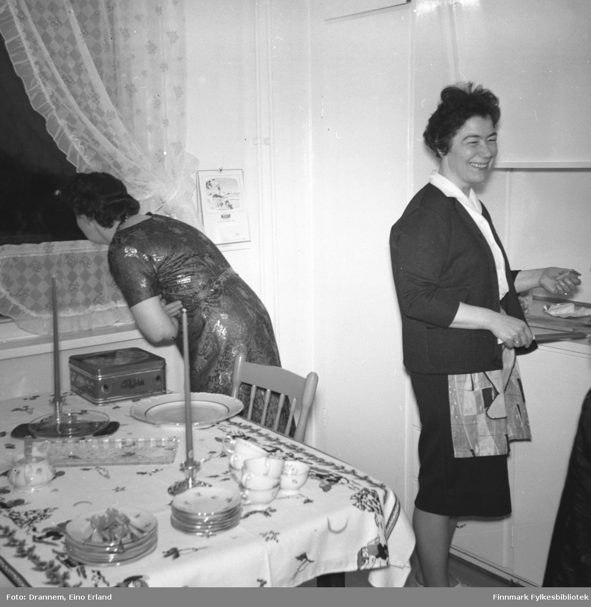 To damer på kjøkkenet til familien Drannem i Hammerfest. Hun til venstre på bildet er ukjent, til høyre står Jenny Drannem.