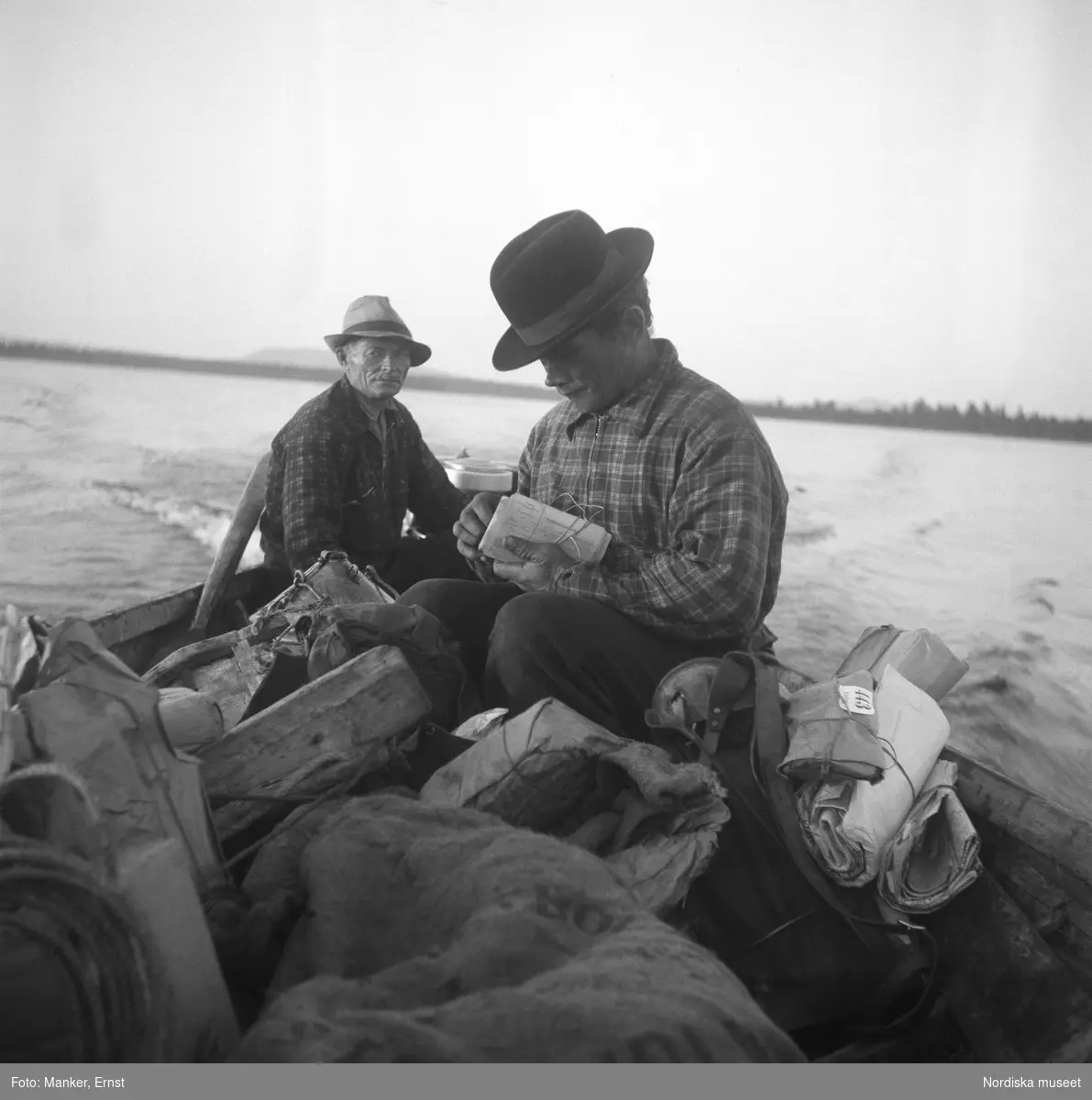 Postföraren Per Andersson från Västerfjäll och Nils Lasko från Örnvik transporterar posten med båt. Under Nordiska museets Lappmarksinventering.