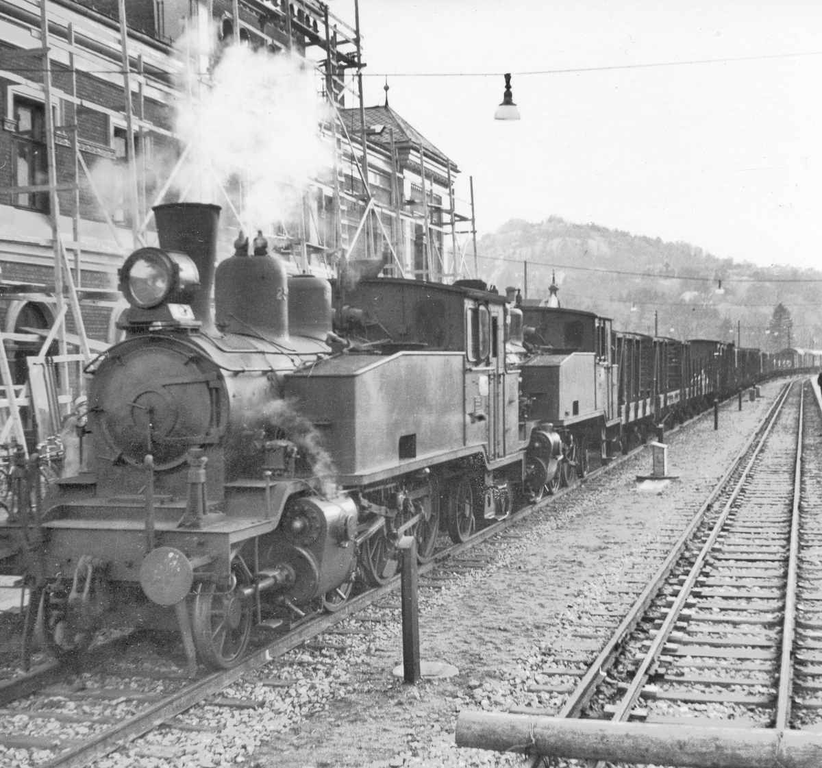 Et av de første normalsporede godstogene ankommer Kristiansand stasjon. Toget trekkes av damplokomotiv 20b 250 (nærmest) og 20b 249.
