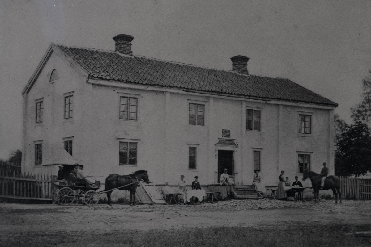 Ryssby herrgårds huvudbyggnad med människor, ryttare, häst och vagn.
