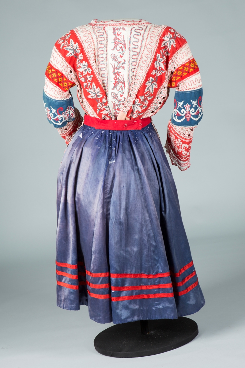 Russisk festdrakt på utstillingsdukke. Bestående av forkle, skjørt og bluse.