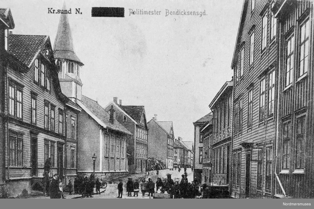 "Kr.sund N. Politimester Bendicksensgd." Foto fra Politimester Bendixens gate på Kirkelandet i Kristiansund. Datering av postkortet er usikkert, men trolig omkring 1910-1920. Fra Nordmøre museums fotosamlinger. EFR2015