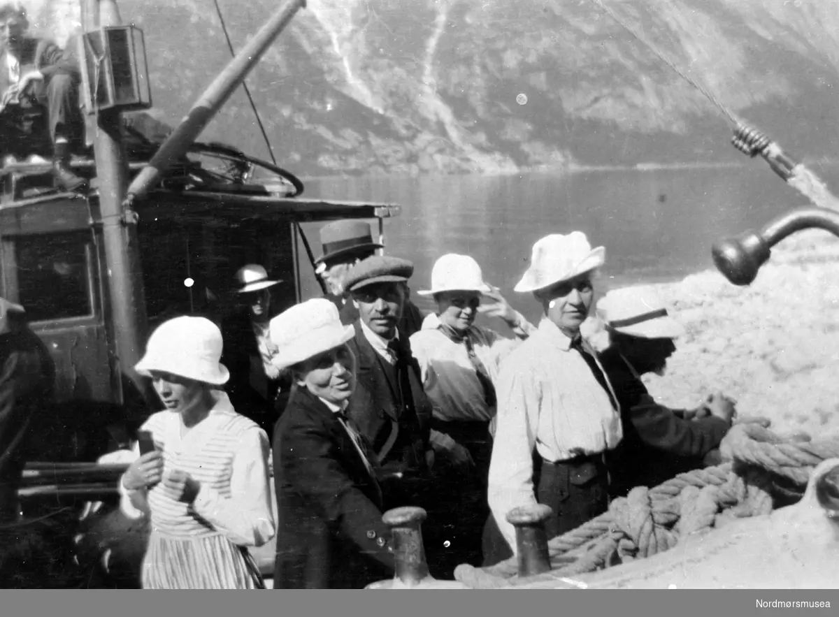 Gruppebilde av fire kvinner og en mann ombord i en skyssbåt? Er de turister? Fra Nordmøre museums fotosamlinger.