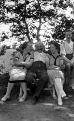 Gruppebilde,
 hvor vi ser to menn og to kvinner sittende ute