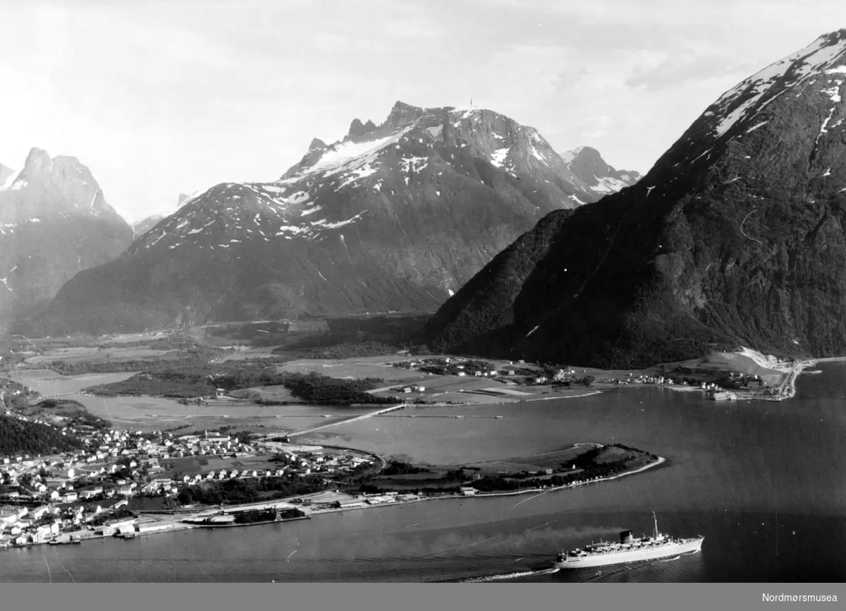 Skipet vi ser er "Caronia" som var nytt i 1948 og tilhørte Cunard Line.  (Info: Magnar Vikøren) - 


Dette er Åndalsnes med omegn. Sentrum nede til venstre. Tangen ut til høyre er Kammen. Der er det nå småbåthavn og friområde med badeplass. Helt til høyre, ved foten av Setnesfjellet, ser vi Veblungsnes, med sandtaket bak. Videre mot venstre Setnes og Setnesmoa. Lenger bak er Sogge og Soggemoen og Hanekamhaug mot Isterdalen som går opp mot høyre bak Setnesfjellet. Fjellformasjonen midt på bildet er Norafjellet med Adelsbreen og Trolltindene, med Store Trolltind som høyeste toppen 1788 moh. Til venstre er Romsdalen med Romsdalshornet 1555 moh. Vi ser Grøttør bru et stykke oppe i elva. Men Åndalsnes Camping og Frydenlund boligfelt er ikke etablert. Rauma bru som er ferdig, ble åpna i november 1963, og oljeeventyret har enda ikke startet på Øran. Men vi ser at elveløpet er regulert ved brua. Så bildet er tatt en gang fra -63 til 70. Turistskip.  - flyfoto av Åndalsnes og Veblungsnes i Rauma kommune. Vi ser Trolltindene og Romsdalshornet. Vi ser at nybrua over Rauma, Rauma bru, er ferdig. Den ble åpna i 1963. Og vi ser at elveløpet er regulert  ovenfor, og nedenfor, brua. Men utfyllinga av Øran er ikke kommet i gang. Så bildet er tatt på 1960-tallet en gang. Fotografen er da mest sansynlig H. Sødahl fra Åndalsnes. (Info:
Eyolf Sæbø) 


Turistskipet på bildet er Cunard Lines RMS Caronia. Caronia gikk jomfrutur i 1949, så bildet er tatt etter den tid.
(info: Espen Arnestad) -  Turistskipet RMS Caronia fra Cunard Lines. Caronia ble tatt i bruk 1949.  Flyfoto av ei bygd, med et større passasjerskip passerende like ved.  
Fra Nordmøre museums fotosamlinger.