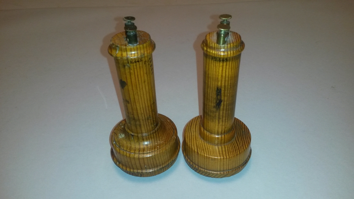 Två magnettelefoner med enkla stavmagneter, enligt Bells konstruktion. Magnetspolarna är fixerade med papper ur en svensk tidning från april år 1878, varav ett stycke se bilagan.