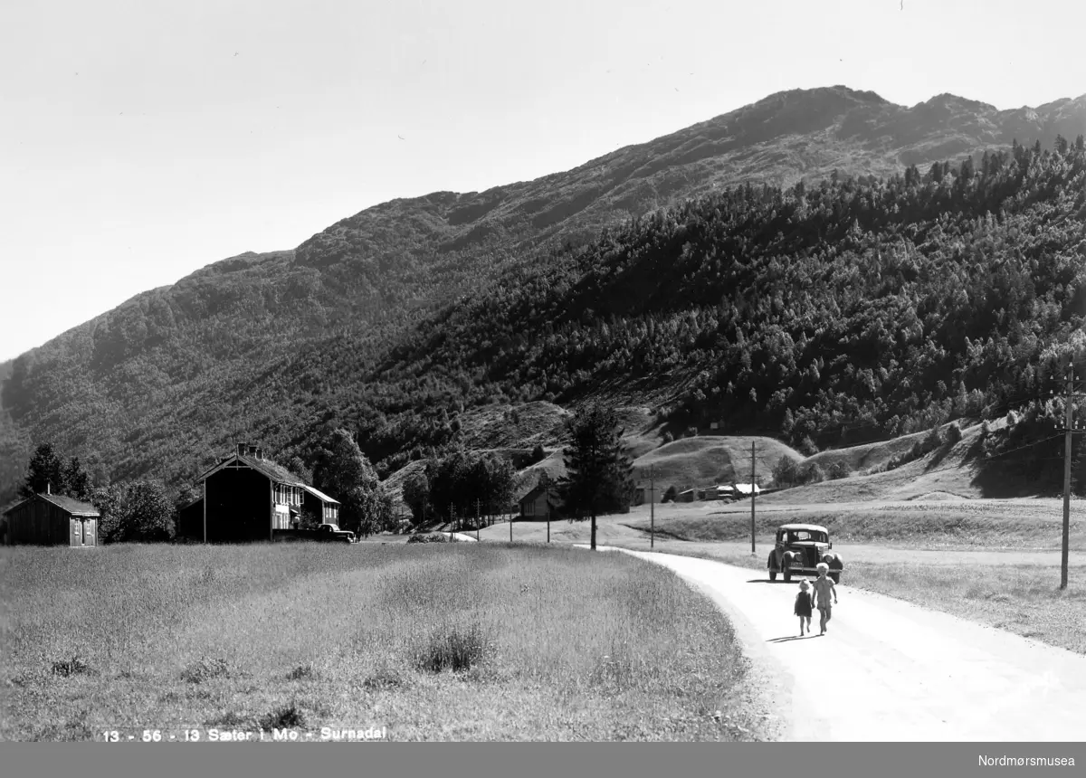 Postkort: ";13-56-13 Sæter i Mo - Surnadal"; Foto fra en landevei i Sæter, Surnadal kommune, hvor vi ser to barn og en bil 
i bakgrunnen. Fra Nordmøre Museums fotosamlinger. Reg: EFR
