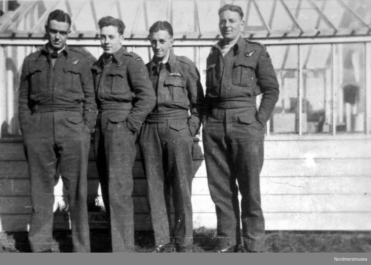 Foto av fire piloter. Fotograf, sted og datering er ukjent, men bildet er trolig fra 4 april 1943, basert på daterte bilder i samme serie.
 I følge informasjon fra Nils Aukans bok Divingguide side 16, er piloten nr. 3 fra venstre, flyoffiser Ralph. C. Dunn fra Christchurch, New Zealand, i cockpiten i hans kampfly ";Hampden";. Hans mannskap ombord i ";Hampden"; med kode ";N";, var navigator G. Crowhurst fra Australia, G. McEachern fra Canada, og H. Segerley også fra New Sealand. De tilhørte en fly-patrulje under tilnavnet ";Rover Trost";, som patruljerte mellom Trondheim og Stavanger. Han var leder for New Zealander 489 squadron. De var tre fly i følge under kodenavn ";P";, ";N"; og ";X";. Se forøvrig foto KMb-1988-016.0001 til og med 0006 i samme serie. (6 foto). Fra Nordmøre Museums fotosamlinger.
