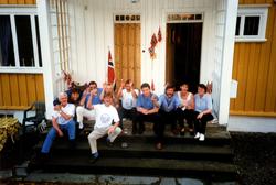 Gruppe mennesker samlet på trappen til et bolighus. Et bilde