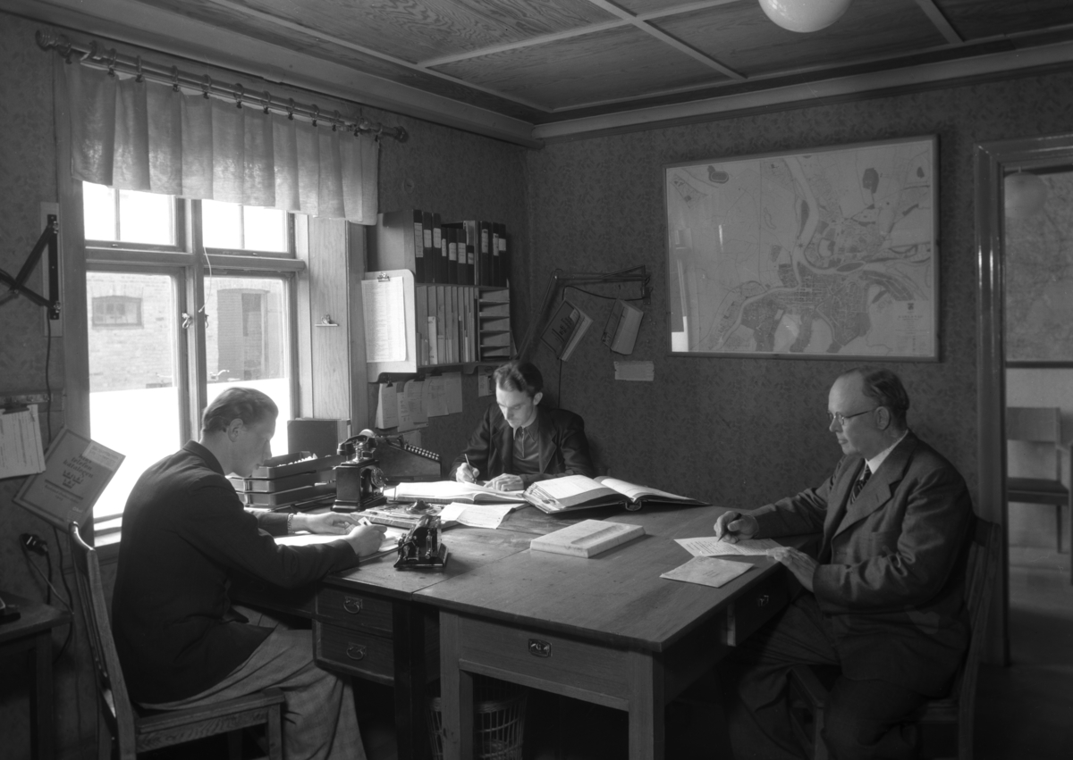 På kontoret hos AB Frans Elinder år 1943.
Mannen till höger är förre kakelugnsmästaren von Knorring. Mannen i mitten är Jarl Wallin som jobbade som kamrer i många år på Elinders, som senare blev Beijer Byggmaterial.