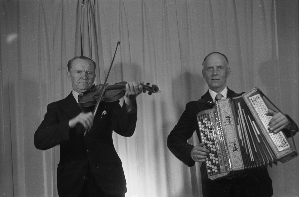 To musikere,en med fiolin og andre med trekkspill