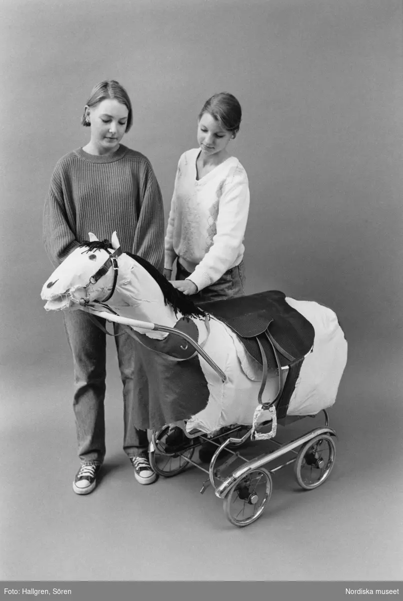 Hästen Twiggy tillsammans med sina skapare. Den hemmagjorda leksakshästen är tillverkad av skumgummi och tyg på stomme av barnvagn, kartong och gammal hatthylla och finns i Nordiska museets samlingar.