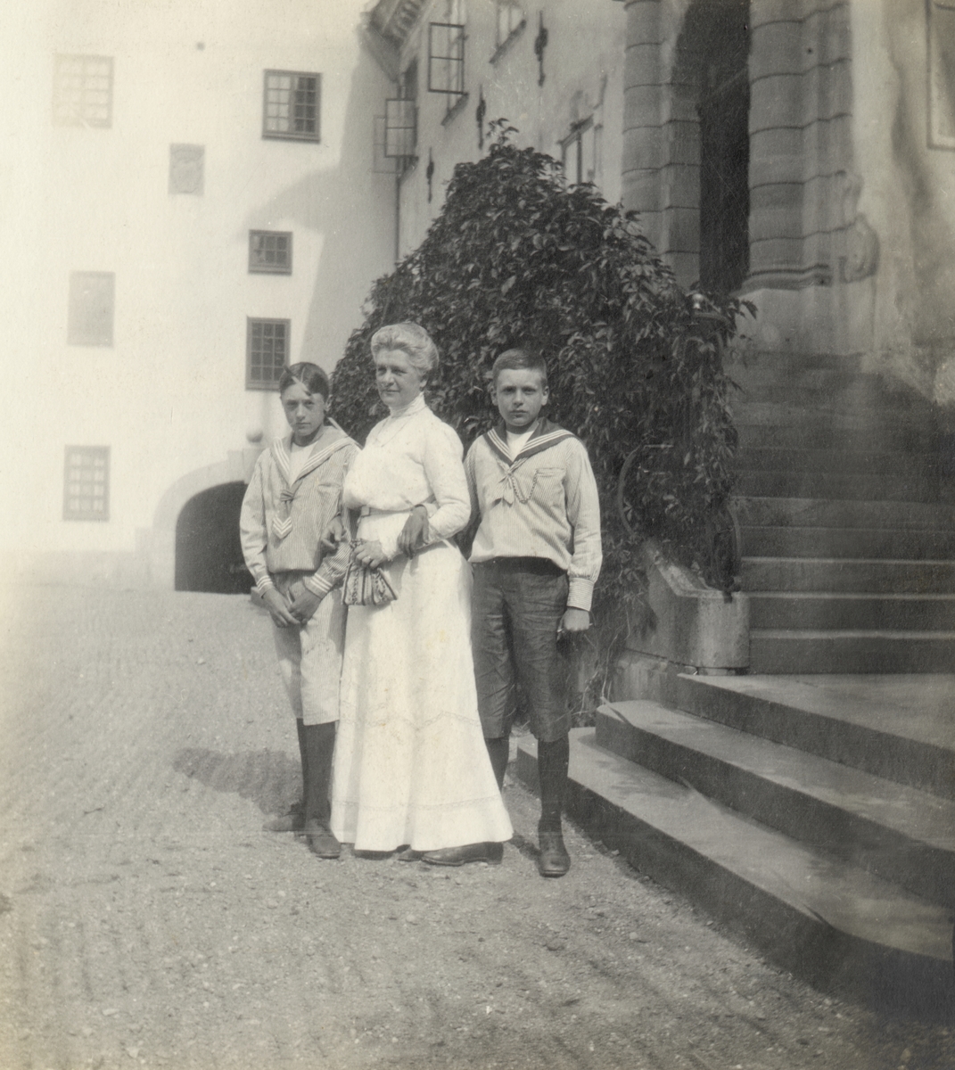 Caroline Lagergren tillsammans med två av sönerna frammför slottstrappan på Tyresö.