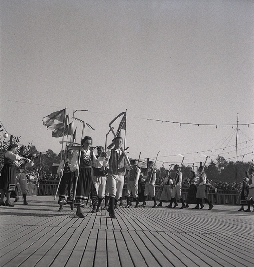 Jubileumsutställning. 
Folkdansuppvisning. Ett foldanslag i Värendsdräkt m.m. visar upp
sig på en dansbana.