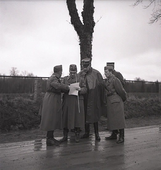 Hemvärnet. 20/4, 1941.
Några officerare i hemvärnet diskuterar något, på en 
regnblöt landsväg.