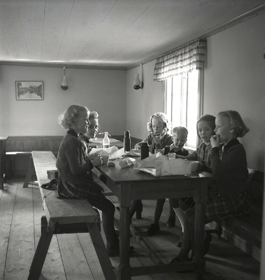 Vårsöndag, 1943. 
Några barn äter matsäck i Fyllerydstugan.