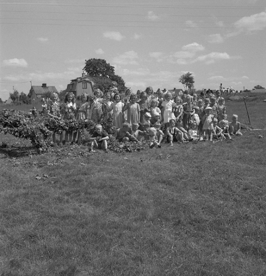 Midsommardansen, 23/6 1946. 
Några barn vid den blivande midsommarstången. I bakgrunden syns några bostadshus.