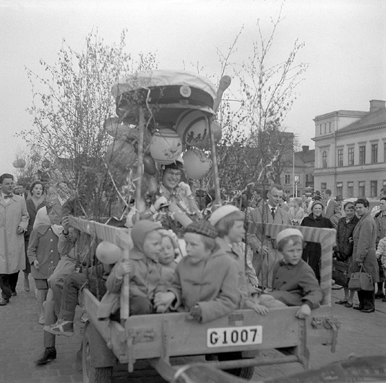 Studenterna sista dagen, 14/5 1958. 
En glad kvinnlig student får skjuts i en lövad kärra på Stortorget. 
Till höger skymtar Stadshotellet.