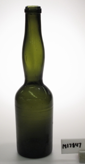 Flaska.
Cylindrisk kropp, hög balusterformad hals.
Grön.
Munblåst. Påklippt regalin, formad med regalinsax.
Funktion: Flaska