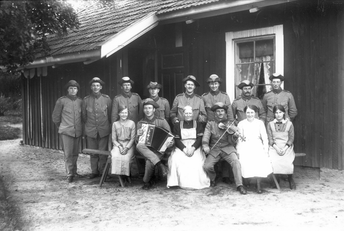 Militärer vid banvaktsstugan intill Ol-Ers. Till vänster Ebba Wikström från Målars, i mitten Sara Ek från Lenninge 2:6, född 1858, hennes dotter Sara, född 1901, samt Anna Fager från Voxsätter 1:11, född 1901. Bilden troligen tagen 1915.