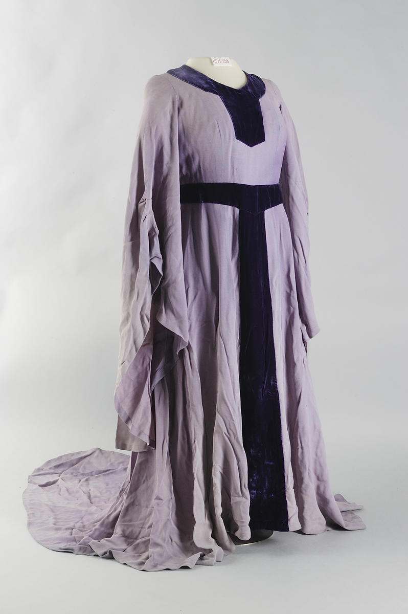 Kostyme Kirsten Flagstad i rollen som Dido i Dido og Aeneas av Henry Purcell. En lilla kjole med svært lange ermer i middelalderstil. Kjolen har et belte rundt livet.