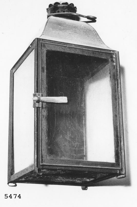Lykta av bleckplåt avsedd för tre ljus. Fyrkantig.

Användes av arbetsgrupperna IP och IH vid arbete i Gamla Dockan, ÖVK, under 1800-talet.
Målad mörkbrun, ljushållare saknas.