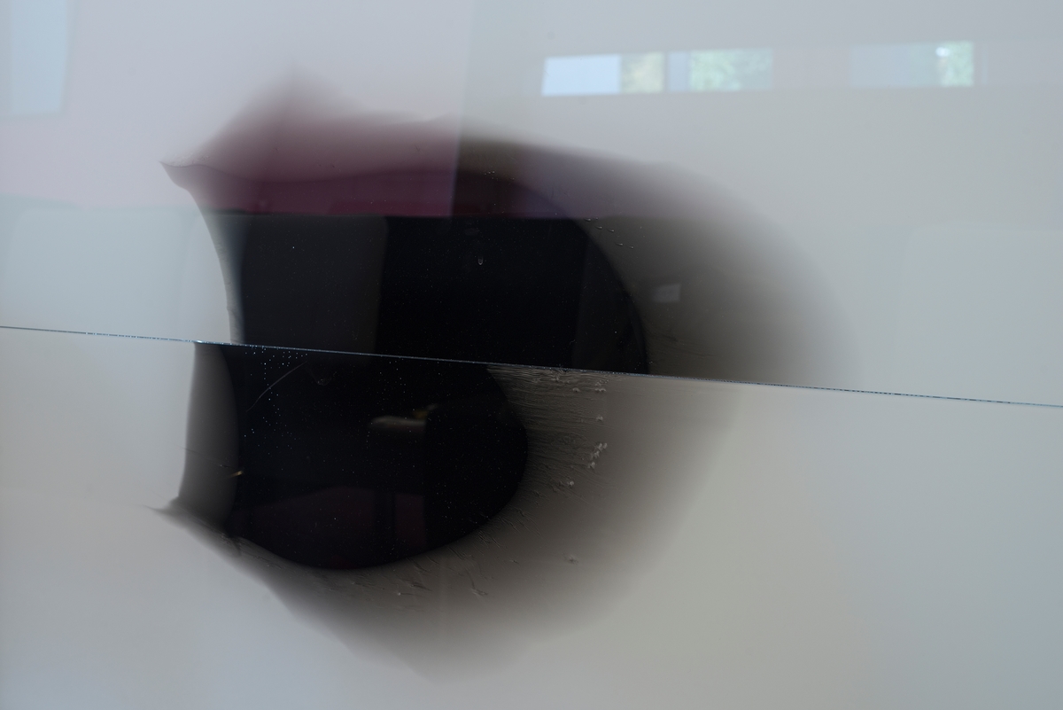 Heuch tilfører med sitt verk noe flyktig, flytende og mykt i form av lette, svarte tegninger på hvitt glass. Dempet fargebruk gir den røde skråveggen i arealet spillerom, samtidig som verkets sorte og hvite fokus gir grafisk kontrast til rødfargen.