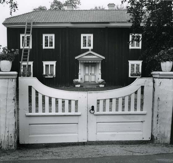 Ingången till Mårtesgården med vitmålad grind.