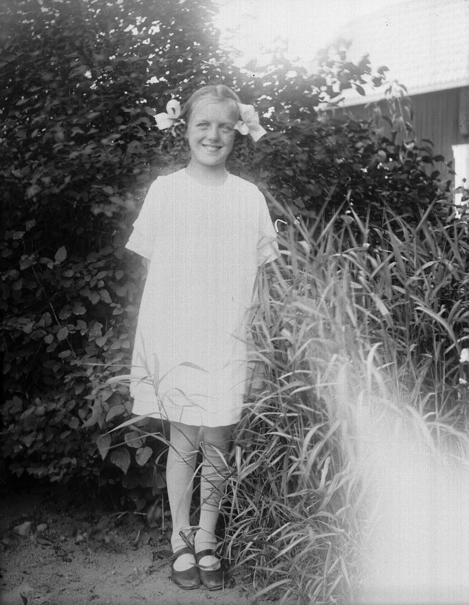 Brita Johanson från Mälby i trädgården i Sävasta, Altuna socken, Uppland 1921