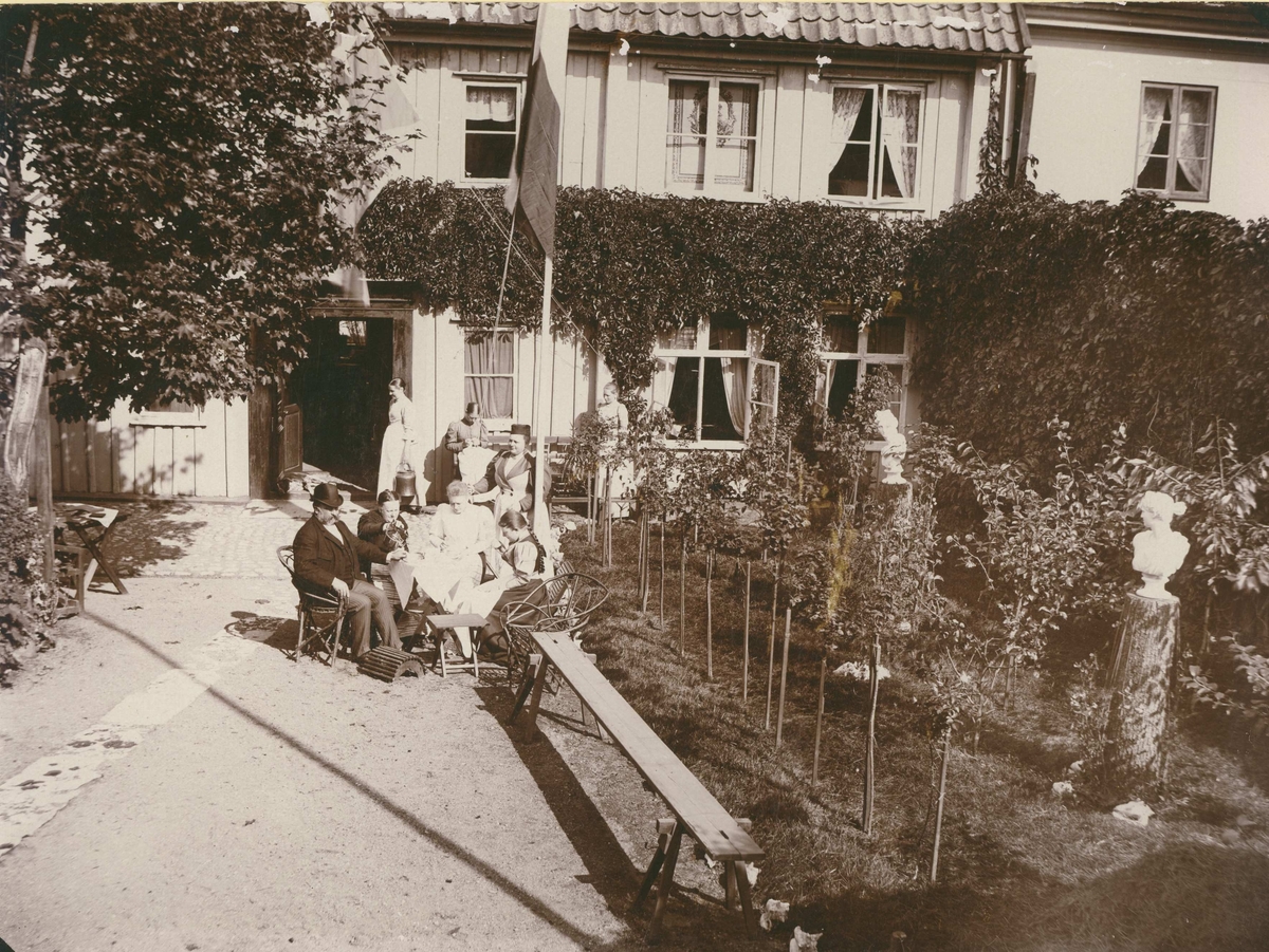 Kaffepaus i trädgården hos familjen Fogelmark.
Här sitter Konsul Rob. Fogelmark, 1838-1909, fru Amelie Fogelmark, född Smith, 1846. Döttrarna Sigrid, 1868-1911, och Gunhild, 1879-1920.